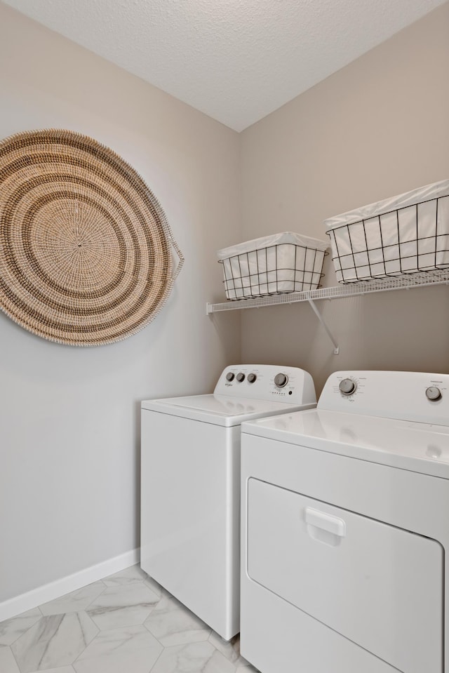 laundry room with separate washer and dryer and a textured ceiling