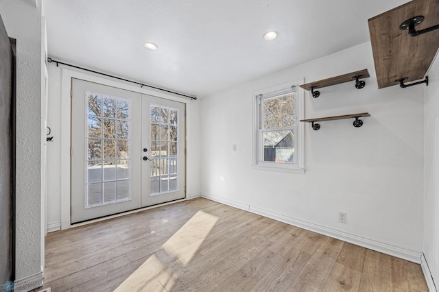 empty room with french doors and light wood-type flooring