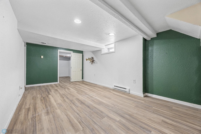 basement with a baseboard radiator, a textured ceiling, and light hardwood / wood-style floors