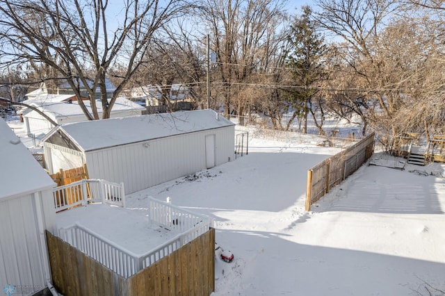 yard covered in snow featuring an outbuilding