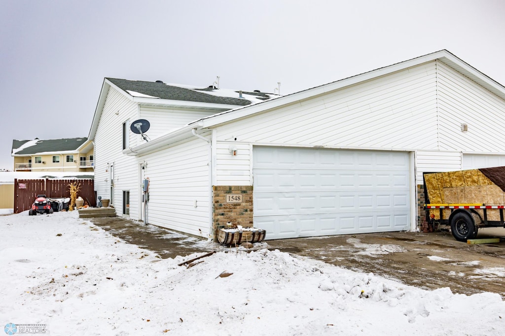 view of snow covered exterior with a garage