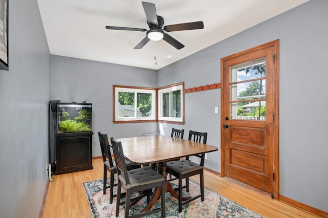 dining room featuring light wood-type flooring, ceiling fan, and baseboards