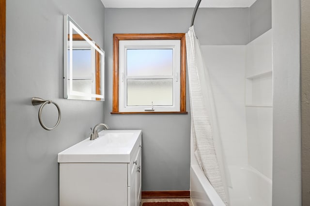 full bath with shower / bath combination with curtain, vanity, and baseboards