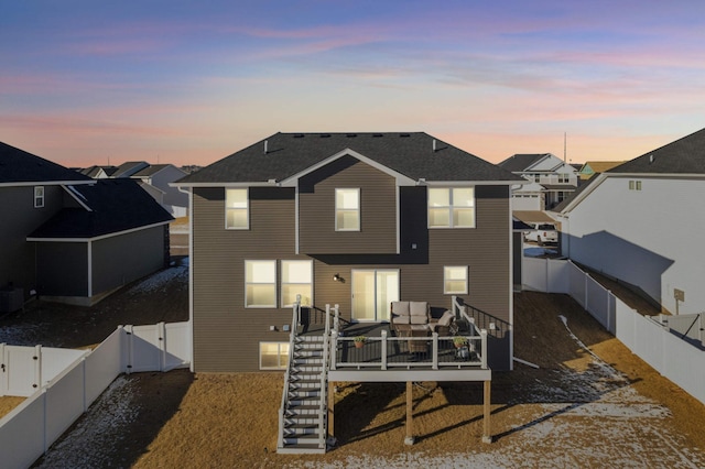 back house at dusk with a deck