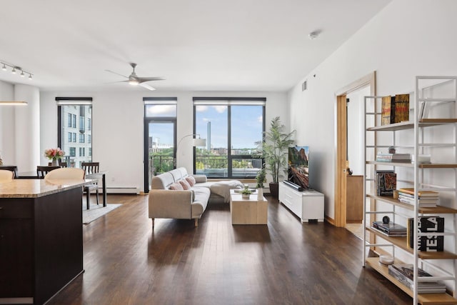 living room with dark hardwood / wood-style flooring, a baseboard heating unit, and ceiling fan