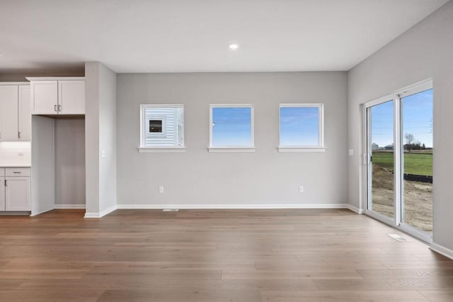 interior space with baseboards, recessed lighting, and light wood-style floors