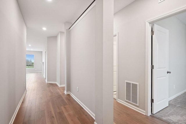 corridor with recessed lighting, wood-type flooring, visible vents, and baseboards