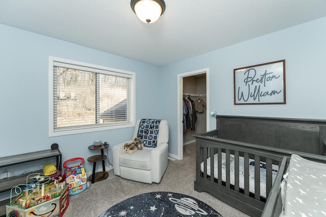 bedroom with a spacious closet, a closet, carpet flooring, and baseboards