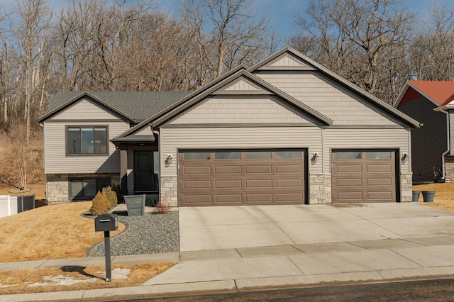 view of front of property featuring a garage, stone siding, and driveway