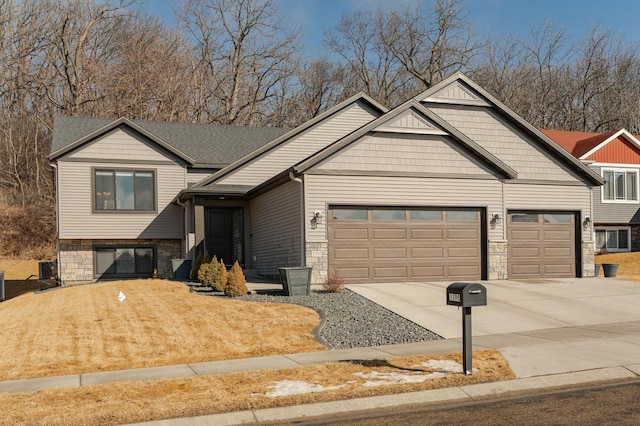 view of front of property featuring stone siding, concrete driveway, an attached garage, and a front yard