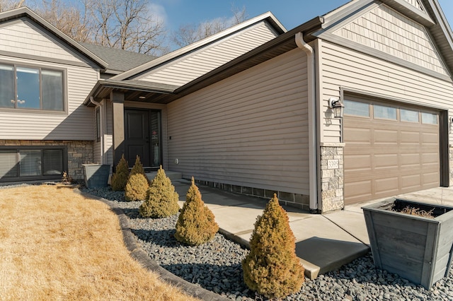 exterior space with an attached garage and stone siding