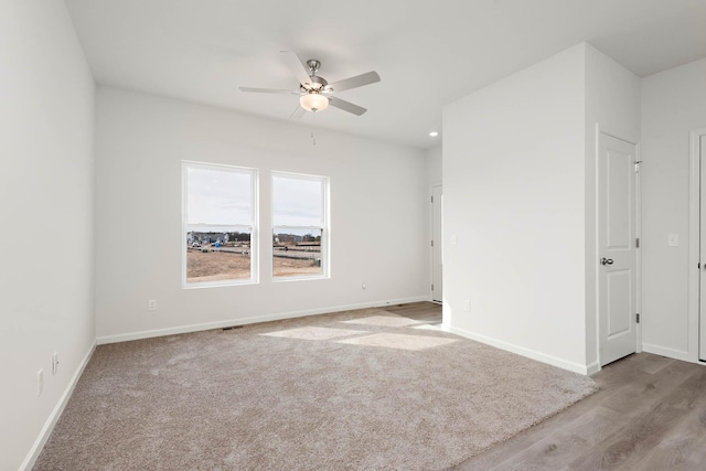 spare room featuring light colored carpet and ceiling fan