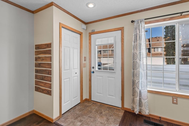 entrance foyer with crown molding and a textured ceiling