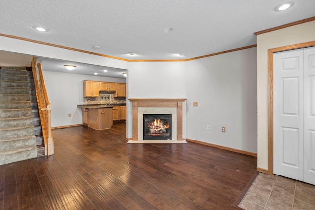 unfurnished living room with ornamental molding, dark hardwood / wood-style floors, and a textured ceiling