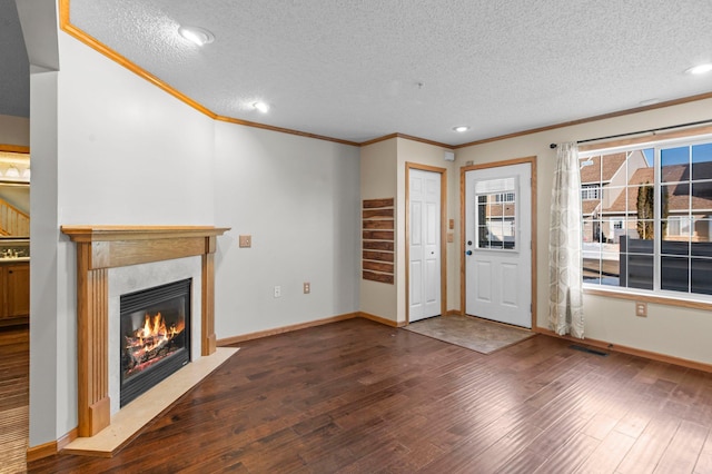 unfurnished living room with dark wood-type flooring, ornamental molding, and a textured ceiling