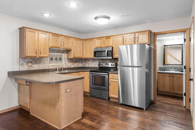 kitchen with dark hardwood / wood-style flooring, kitchen peninsula, a textured ceiling, and appliances with stainless steel finishes