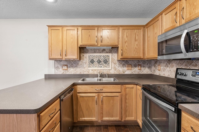 kitchen with sink, dark hardwood / wood-style flooring, decorative backsplash, stainless steel appliances, and a textured ceiling