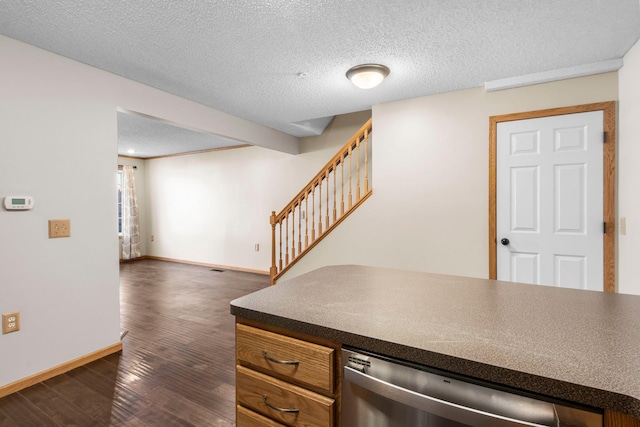 kitchen featuring stainless steel dishwasher, dark hardwood / wood-style floors, and a textured ceiling