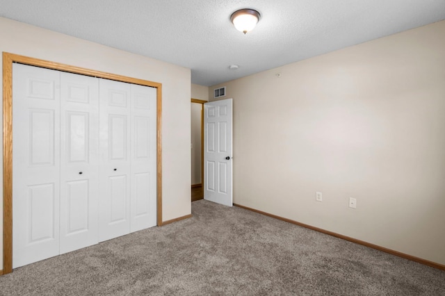 unfurnished bedroom featuring light colored carpet, a closet, and a textured ceiling