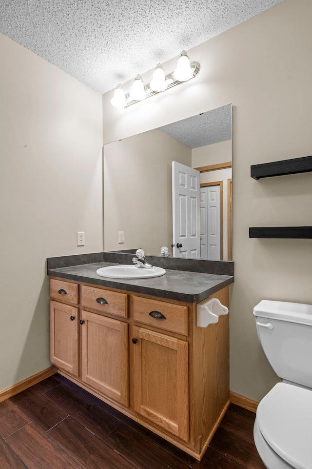 bathroom with vanity, a textured ceiling, and toilet