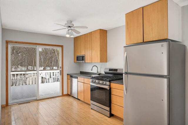 kitchen with stainless steel appliances, ceiling fan, sink, and light wood-type flooring