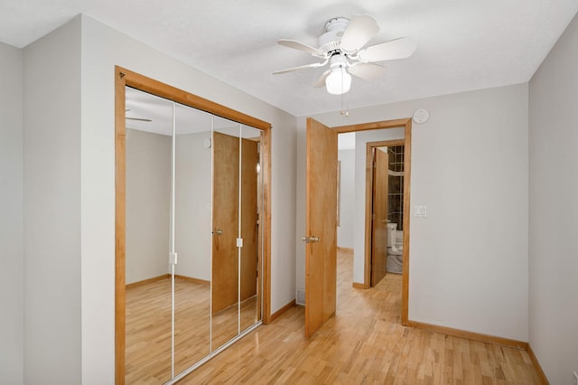 unfurnished bedroom with ceiling fan, a closet, and light hardwood / wood-style flooring