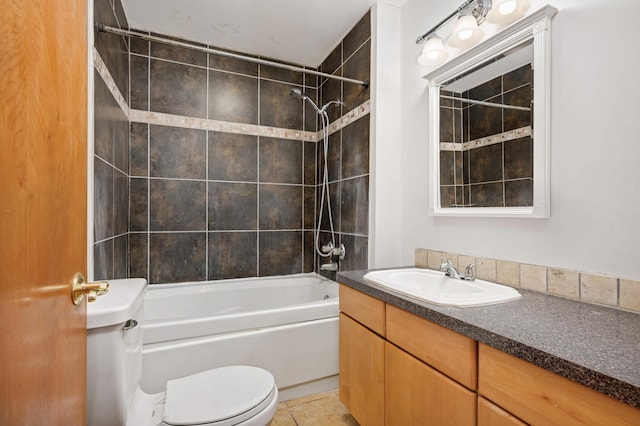 full bathroom featuring tile patterned flooring, tiled shower / bath, vanity, and toilet