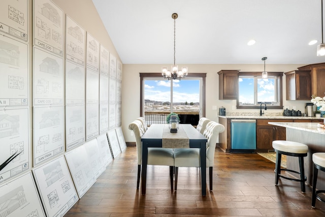 dining area with vaulted ceiling, dark hardwood / wood-style floors, and an inviting chandelier