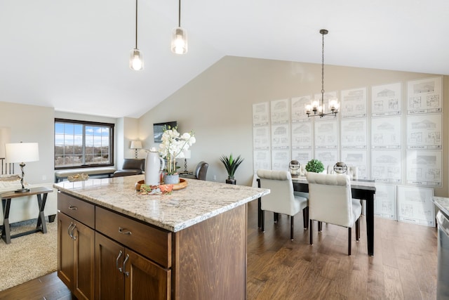 kitchen with pendant lighting, lofted ceiling, dark wood-type flooring, and a kitchen island