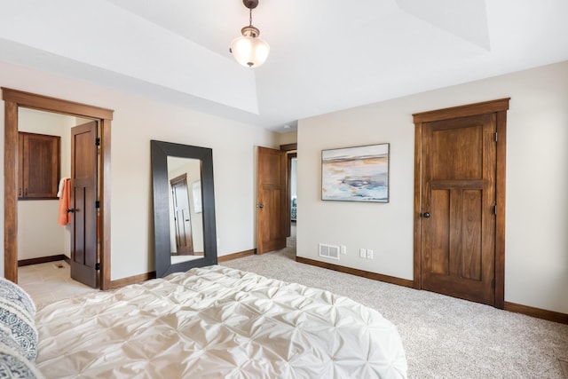 unfurnished bedroom featuring light colored carpet and a tray ceiling