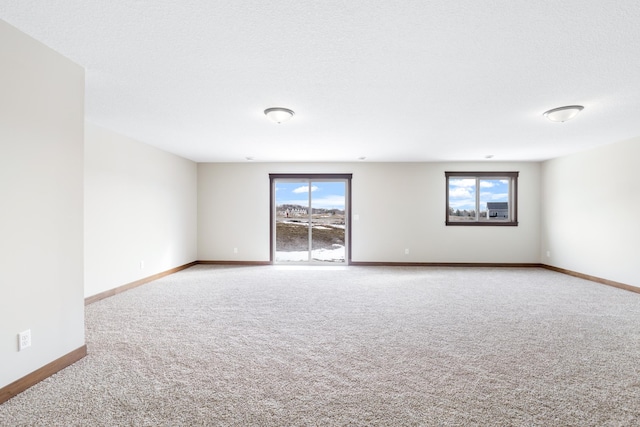 carpeted spare room featuring a textured ceiling