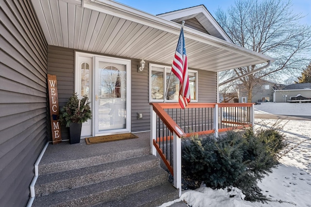 snow covered property entrance featuring covered porch