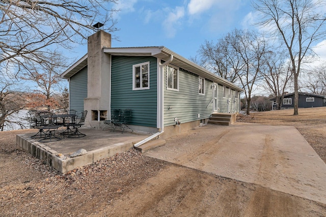 back of property with a patio area and a chimney