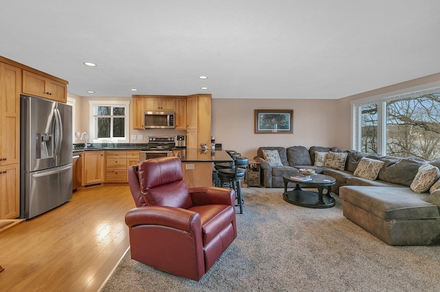 living area featuring light wood-style flooring and recessed lighting