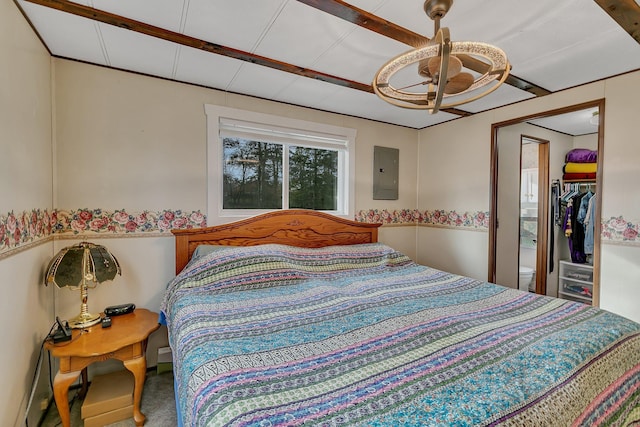 bedroom featuring electric panel, ceiling fan, a closet, a walk in closet, and carpet flooring