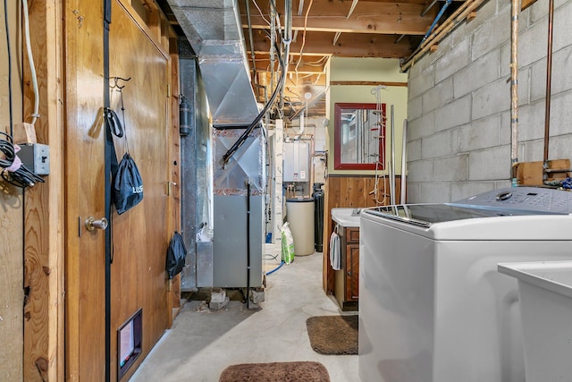 unfinished below grade area with a sink, washer / clothes dryer, concrete block wall, and water heater