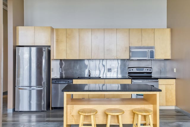 2929 Chicago Ave Unit 1216, Minneapolis, MN 55407 - kitchen with stainless steel appliances, light brown cabinetry, decorative backsplash, dark wood-style flooring, and dark countertops