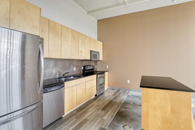 2929 Chicago Ave Unit 1216, Minneapolis, MN 55407 - kitchen featuring appliances with stainless steel finishes, light brown cabinetry, dark countertops, tasteful backsplash, and light wood finished floors
