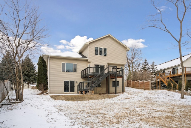 snow covered property with stairs and a wooden deck