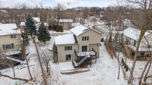 snow covered rear of property featuring stairway