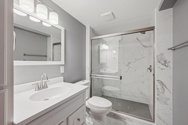 bathroom featuring a marble finish shower, vanity, and toilet