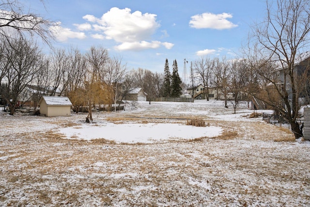 yard covered in snow with an outbuilding and a storage shed