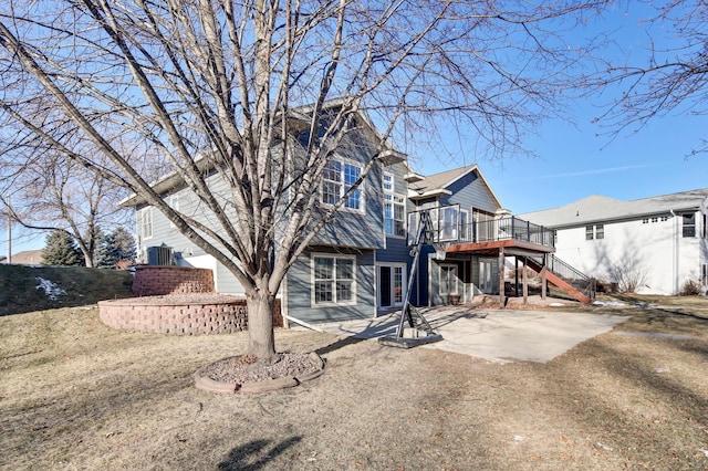 rear view of house featuring central AC unit, a yard, a patio, and a deck