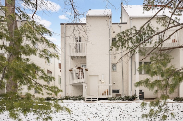 snow covered property featuring central AC unit