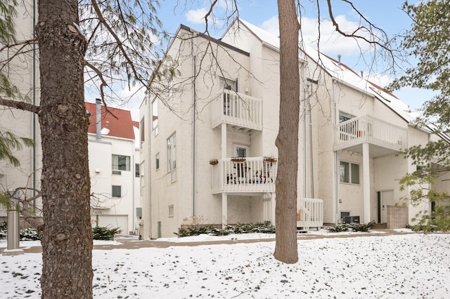 snow covered property featuring central AC