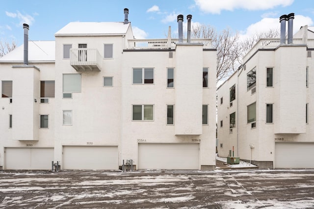 view of building exterior featuring central AC unit and a garage