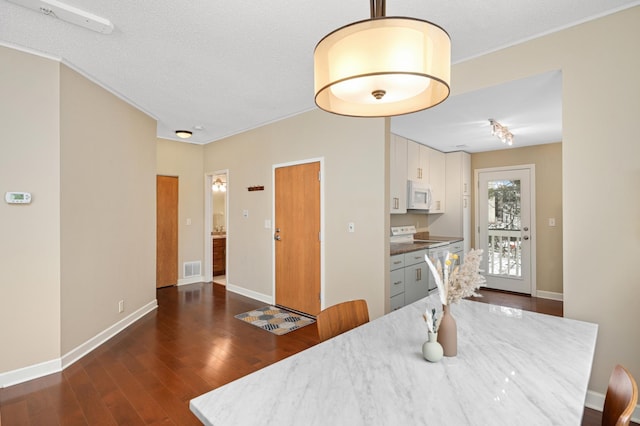 3054 Lake Shore Dr Unit B, Minneapolis, MN 55416 - dining room with baseboards, visible vents, dark wood-style flooring, and crown molding
