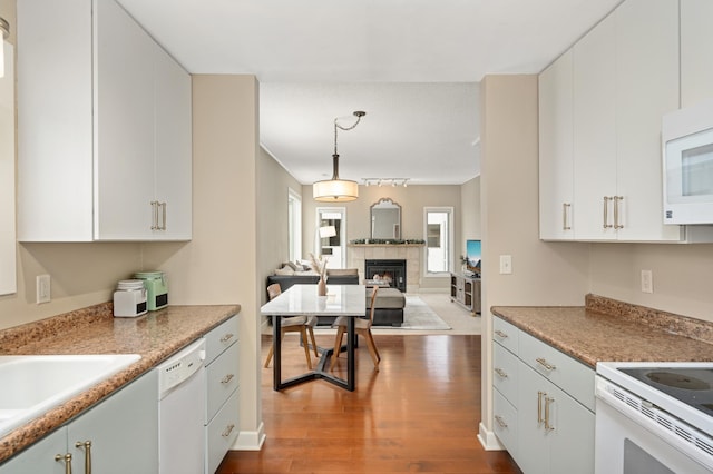 3054 Lake Shore Dr Unit B, Minneapolis, MN 55416 - kitchen featuring dark wood-style flooring, a tiled fireplace, white appliances, pendant lighting, and open floor plan