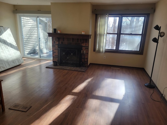 living room featuring dark hardwood / wood-style floors, a wealth of natural light, and a fireplace