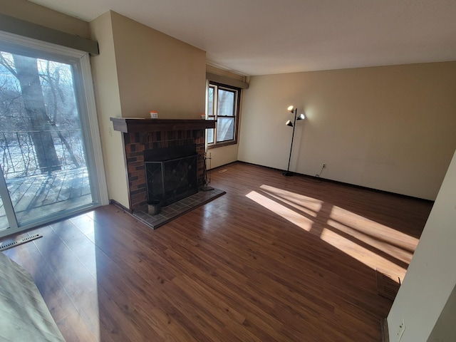 unfurnished living room featuring a fireplace and dark hardwood / wood-style flooring